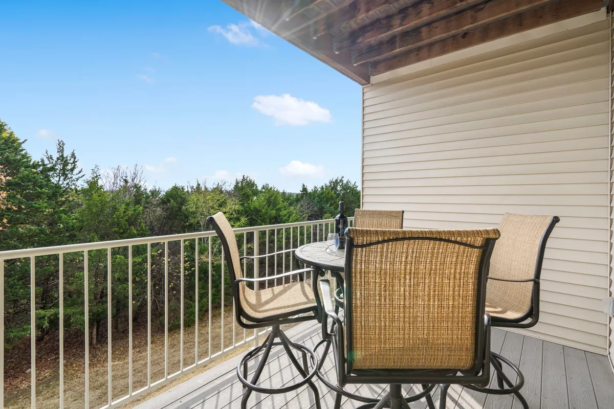 A stylish outdoor dining set is set against a backdrop of lush greenery and a clear blue sky. The space exudes a welcoming atmosphere, perfect for morning coffee, brunch, or evening drinks while immersed in nature.
