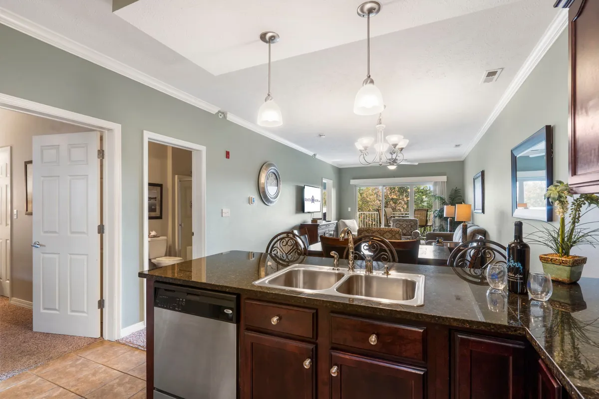 A wide-angle view of the open-plan kitchen, seamlessly connected to the dining area and living room with an outdoor view in the background. The kitchen island stands out as a central gathering point, and the flow between spaces suggests the ideal setup for entertaining or relaxing with family and friends.